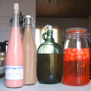 Bouteilles et bocaux colorés faits maison sur table.