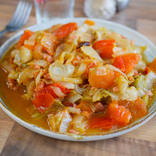 Plat de chou cuisiné aux lardons et tomates.
