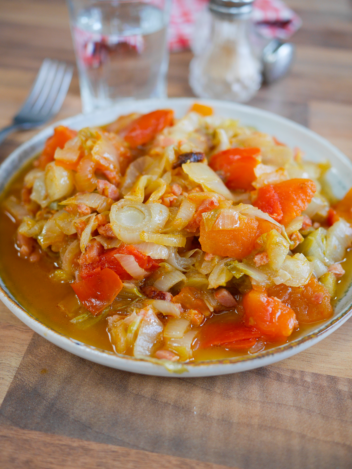 Plat de chou cuisiné aux lardons et tomates.