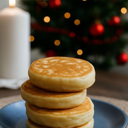 Pile de crumpets, bougie et sapin de Noël en arrière-plan