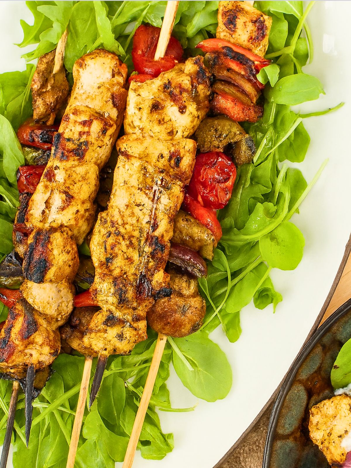 Brochettes de poulet grillées sur lit de roquette