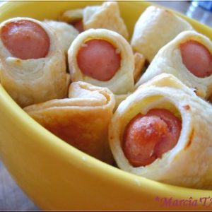 Bouchées de saucisses en pâte feuilletée dans bol jaune.