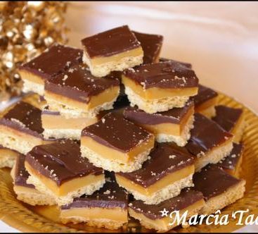 Carrés caramel chocolat sur un plat doré.