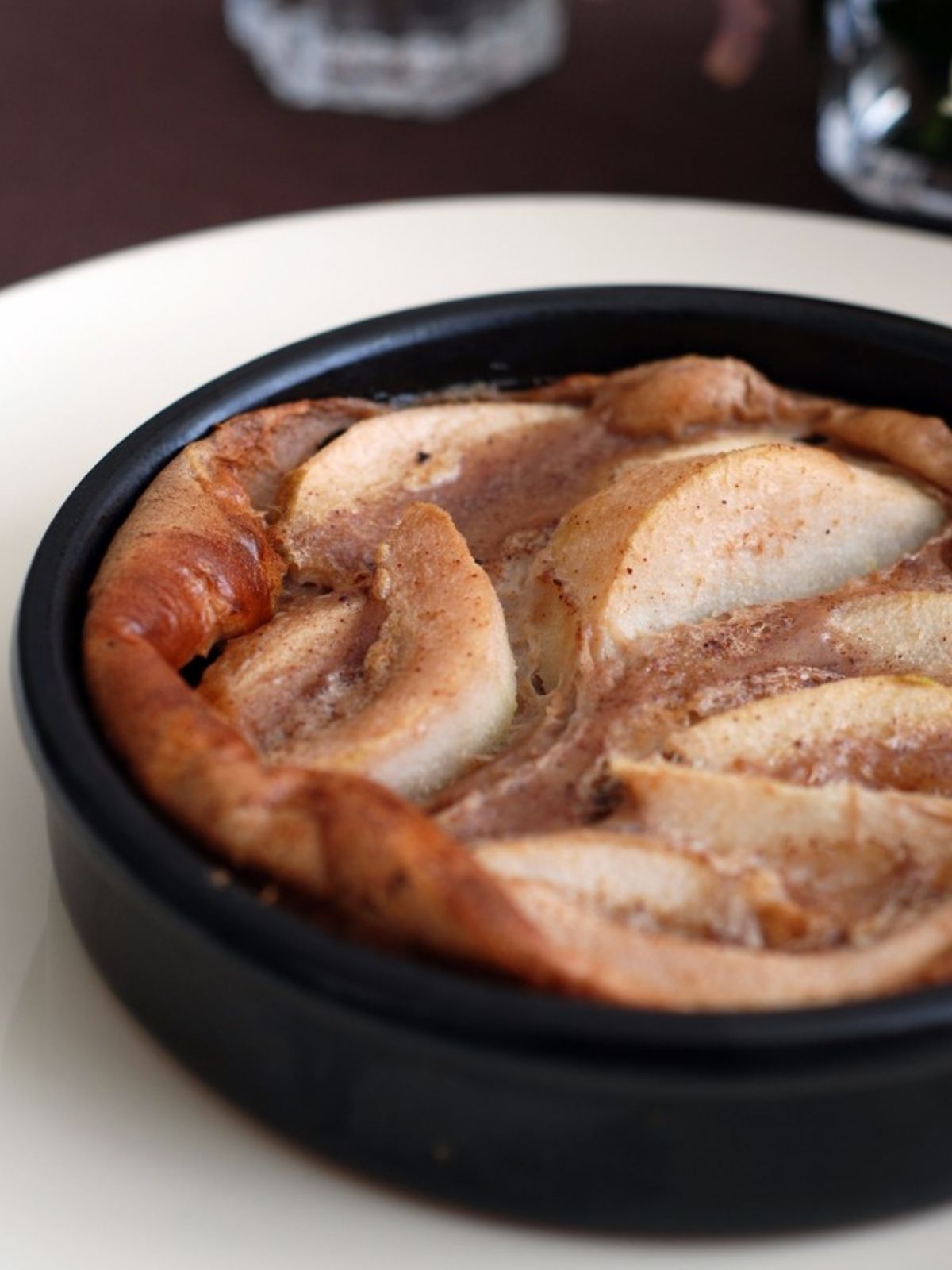 Tarte aux pommes rustique dans un plat noir.