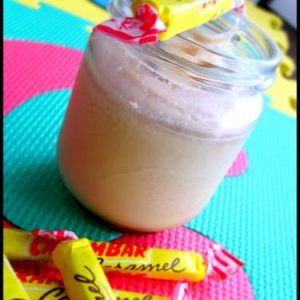 Boisson au caramel avec bonbons Carambar sur fond coloré.