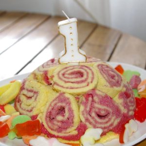 Gâteau d'anniversaire avec bougie numéro 1 et bonbons.