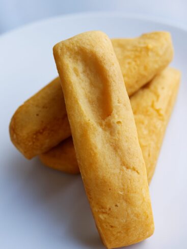 Quatre biscuits shortbread rectangulaires sur une assiette blanche.