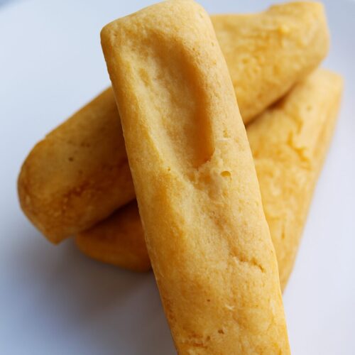 Quatre biscuits shortbread rectangulaires sur une assiette blanche.