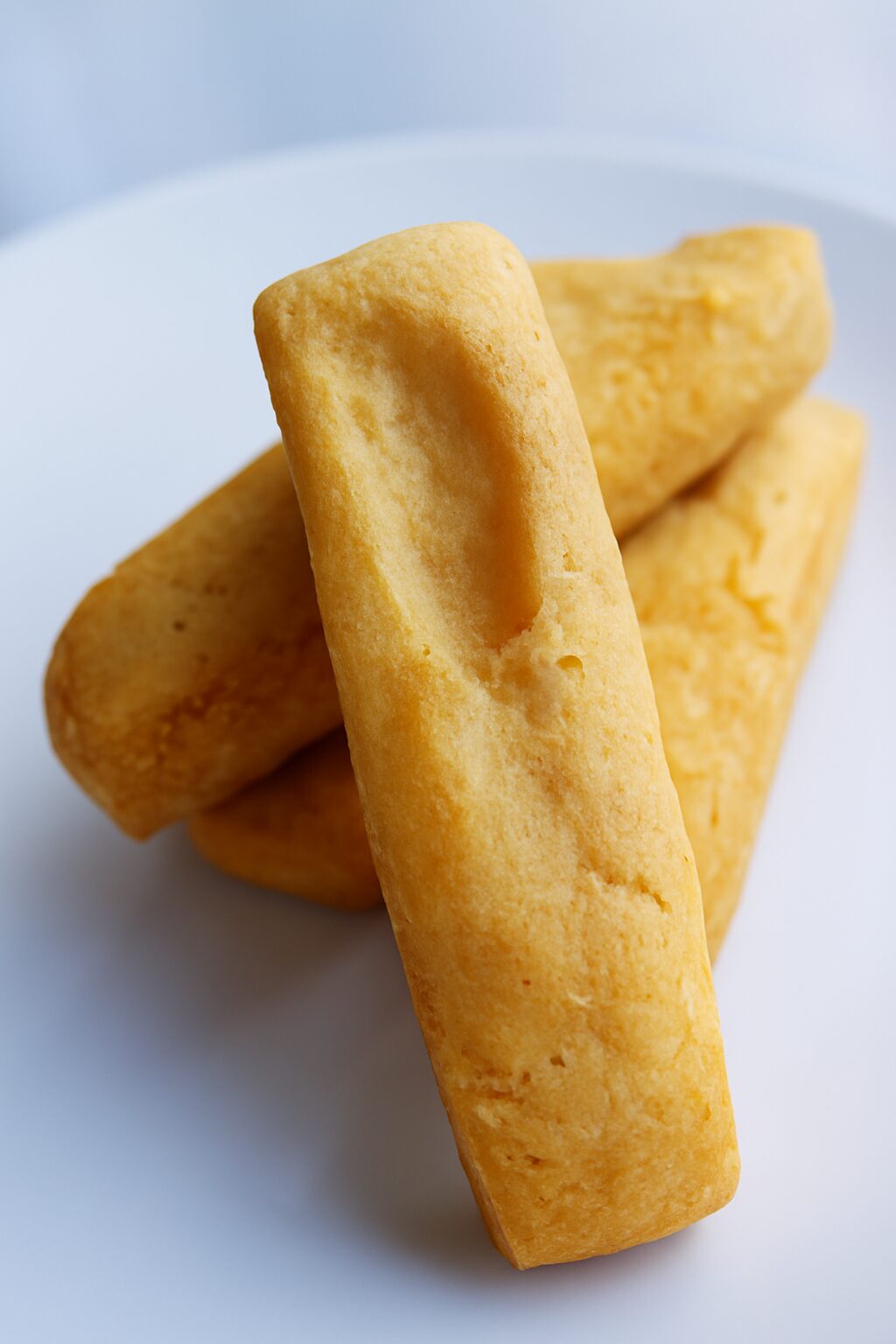 Quatre biscuits shortbread rectangulaires sur une assiette blanche.