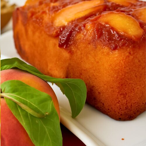 Gâteau renversé aux pêches avec pêche fraîche et feuilles.
