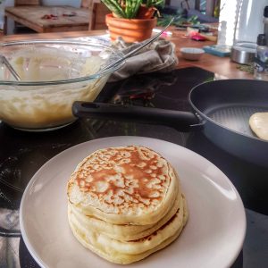 Pile de pancakes faits maison sur une table de cuisine.