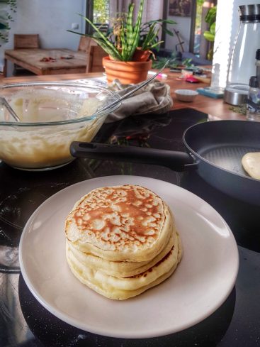 Pile de pancakes faits maison sur une table de cuisine.