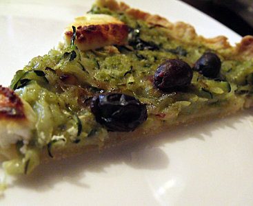 Part de tarte courgette, chèvre et olives