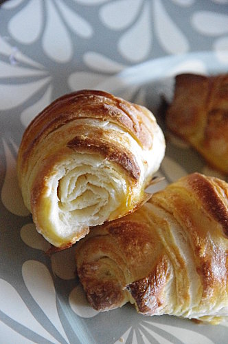 Croissants frais et dorés sur une assiette fleurie