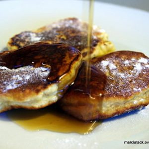 Pancakes saupoudrés de sucre glace nappés de sirop.