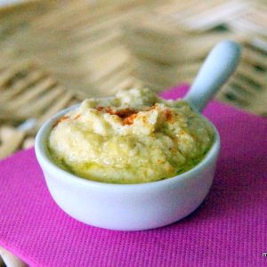 Houmous maison dans ramequin blanc sur serviette rose