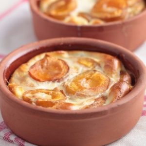 Clafoutis aux abricots dans des ramequins en terre cuite.
