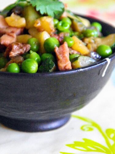 Petits pois aux lardons servis dans un bol en céramique noir