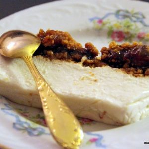 Cheesecake avec confiture sur assiette fleurie et cuillère