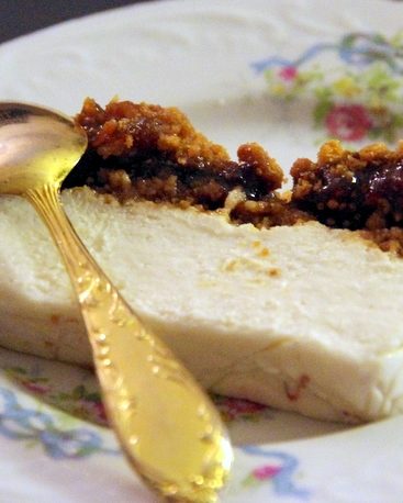 Cheesecake avec confiture sur assiette fleurie et cuillère