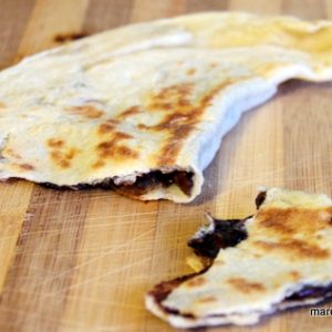Crêpe fourrée sur planche à découper en bois.