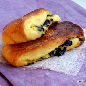 Deux pains aux olives sur tissu violet.