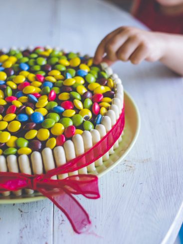 Gâteau décoré de bonbons colorés et ruban rouge
