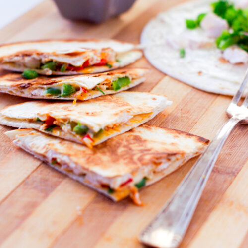 Quesadillas au poulet et légumes sur planche en bois.