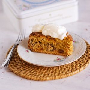 Gâteau aux carottes avec crème et boîte décorée.