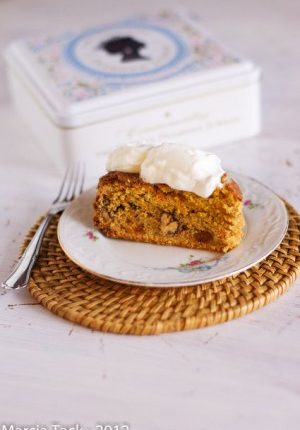 Gâteau aux carottes avec crème et boîte décorée.