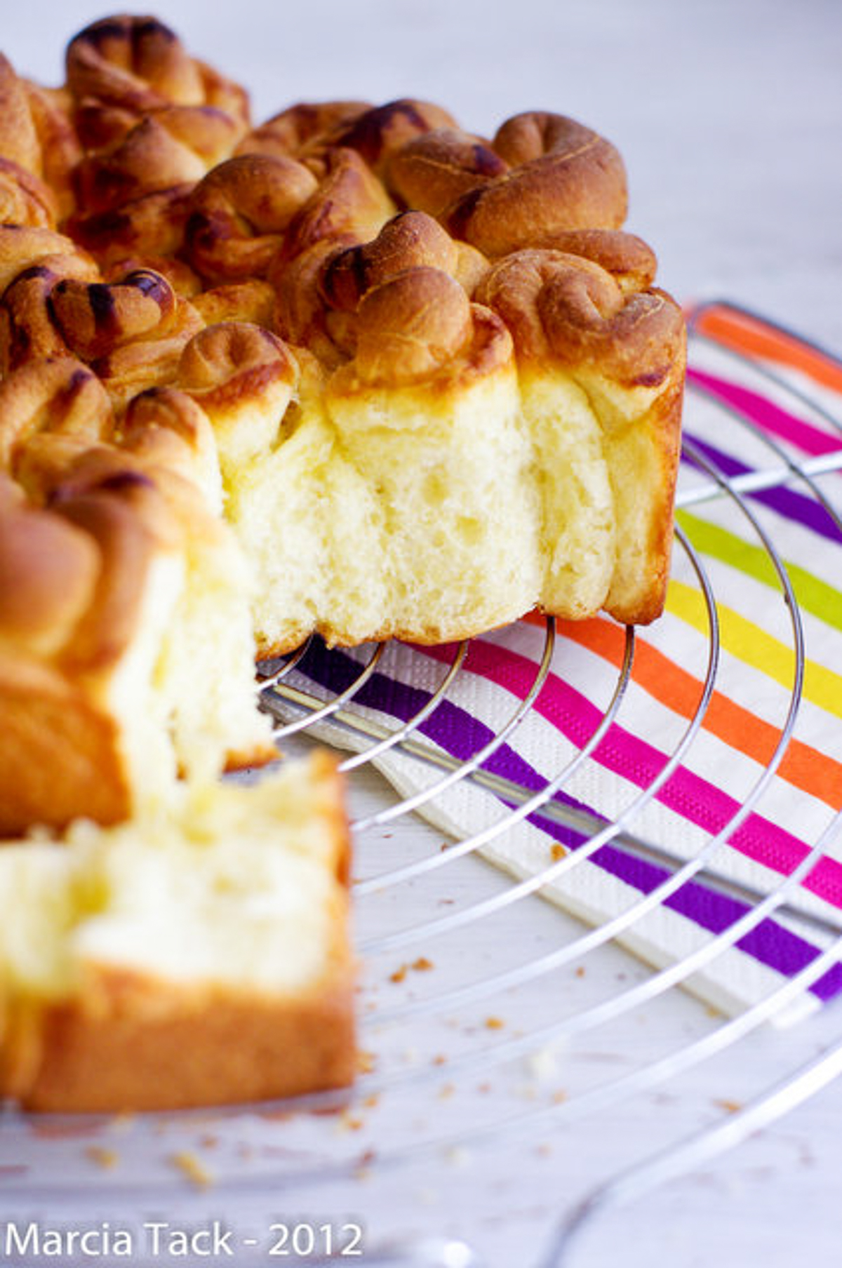 Brioche moelleuse faite maison, sur grille et serviette rayée.