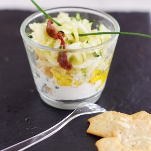 Verrine apéritive colorée avec crudités et crackers.