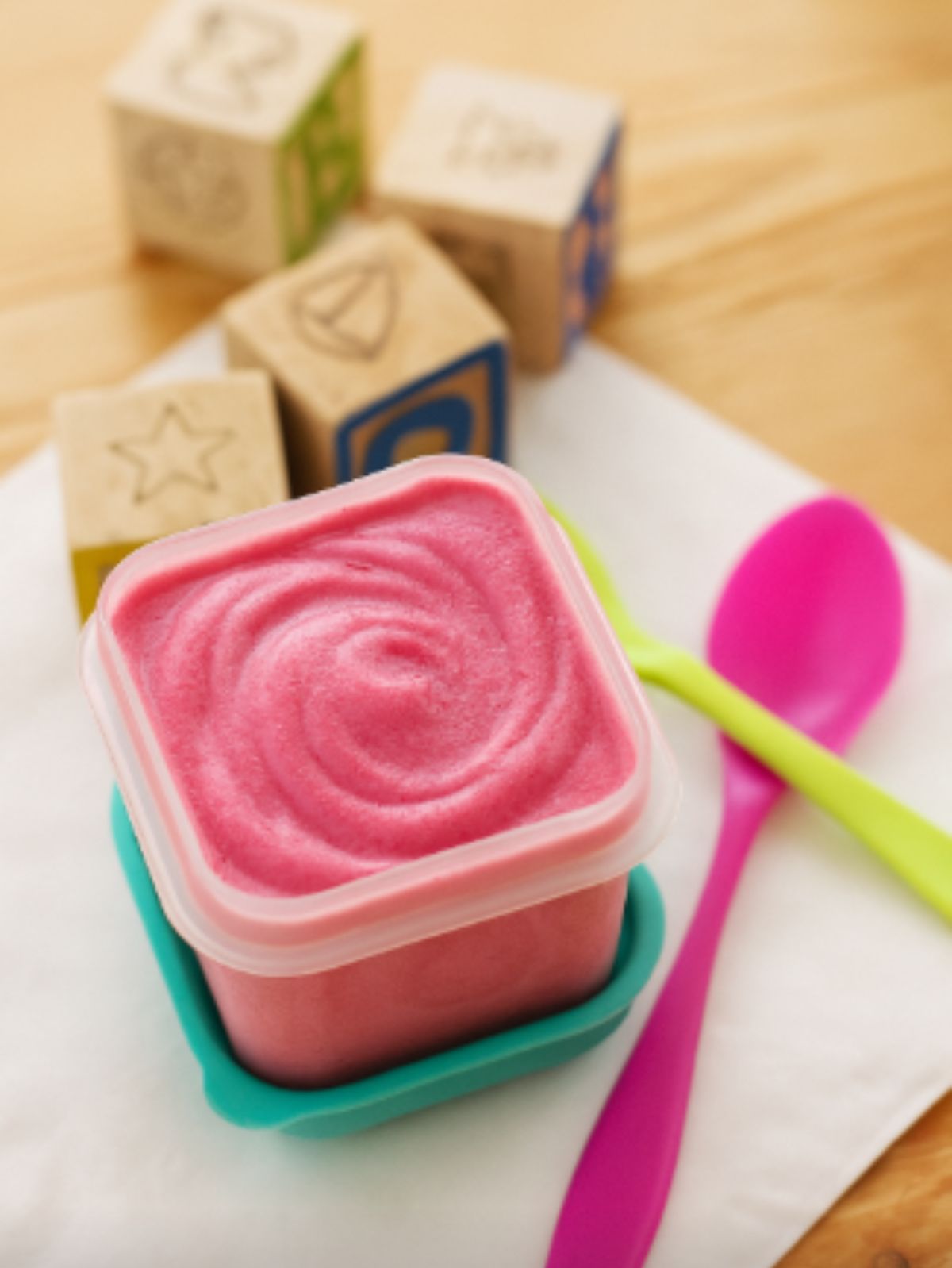 Purée de fruits rose pour bébé, avec jouets