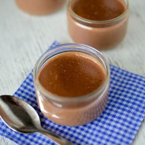Crèmes au chocolat en pots, cuillère et serviette.