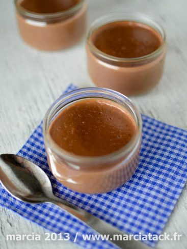 Crèmes au chocolat en pots, cuillère et serviette.