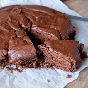 Gâteau au chocolat moelleux coupé, sur papier sulfurisé.