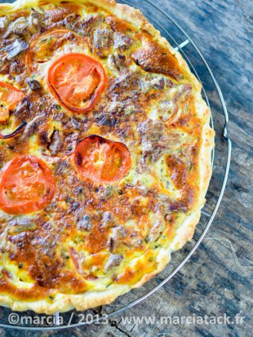 Quiche aux tomates maison sur grille, aspect appétissant.