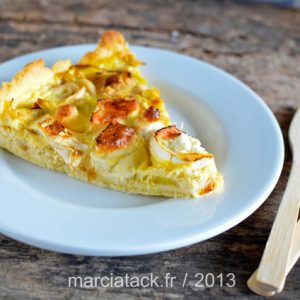 Part de tarte aux légumes sur assiette blanche.