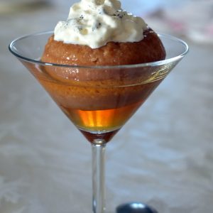 Baba au rhum avec crème dans un verre à cocktail
