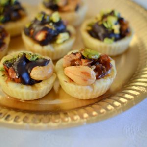Mini tartelettes aux noix et chocolat sur plateau doré