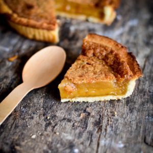 Tarte au sucre et cuillère en bois sur bois.