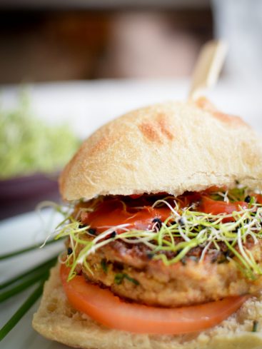 Burger végétarien avec tomates et graines germées.