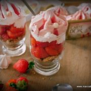 des verres remplis de fraises, de biscuits et de glace