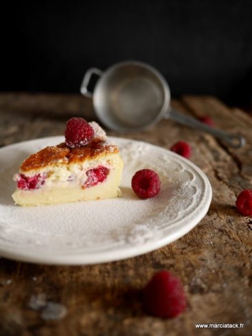 Part de tarte aux framboises saupoudrée de sucre glace.
