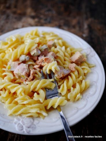 Pâtes fusilli au saumon sur assiette blanche.