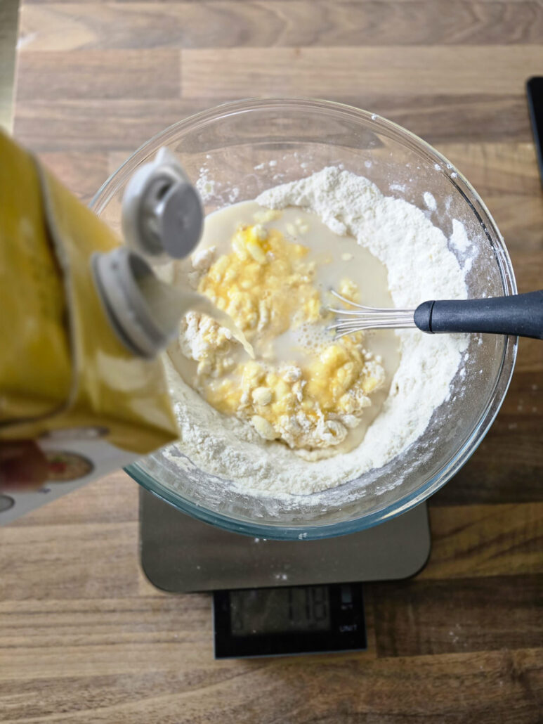 lait versé petit à petit dans la pâte à crêpes pour ne pas avoir de grumeaux