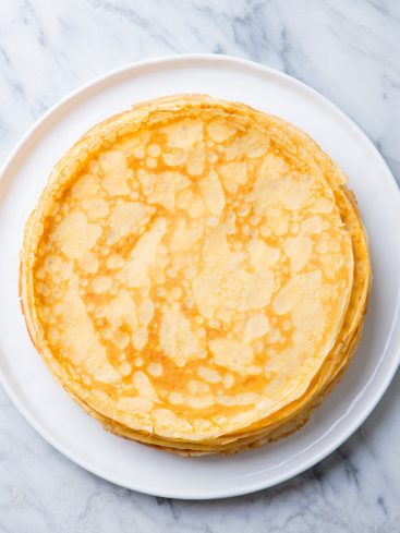Pile de crêpes sur une assiette blanche