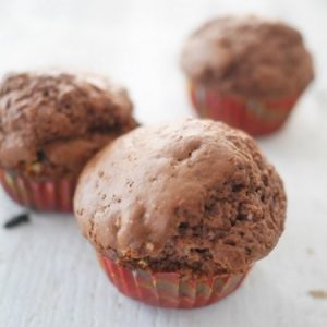 Trois muffins au chocolat en moules rouges.