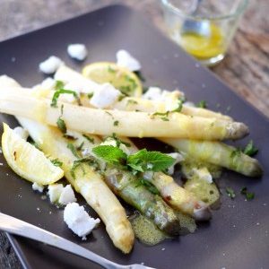 Assiette d'asperges blanches, feta, citron et herbes fraîches.