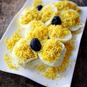 Œufs mimosa avec olives noires sur plat blanc